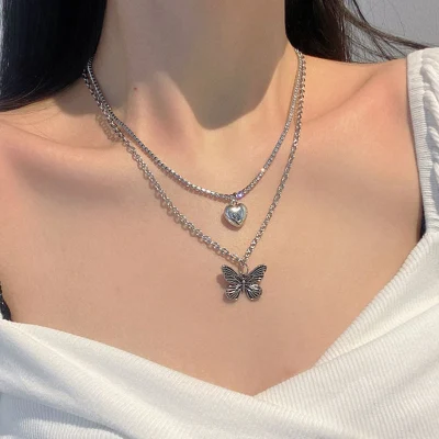 Finetoo Collier ras du cou asymétrique en perles avec pendentif en forme de cœur et de papillon